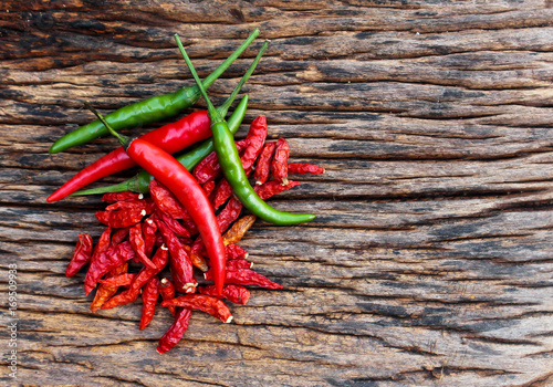 Dried peppers and chilli peppers on wood background.
