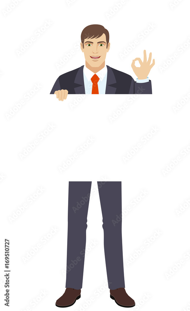 Businessman holding white blank poster and showing a okay hand sign Businessman holding white blank poster and showing a okay hand sign