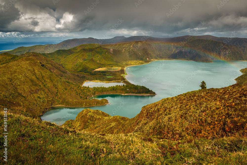 Wide angle view of the Lagoa do Fogo - Lake of Fire - with a rainbow in the island of Sao Miguel, The Azores, Portugal. The archipelago of the Azores is a hidden gem holiday destinations in Europe.
