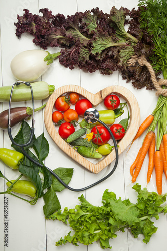 Fresh vegetables and heart on a white background