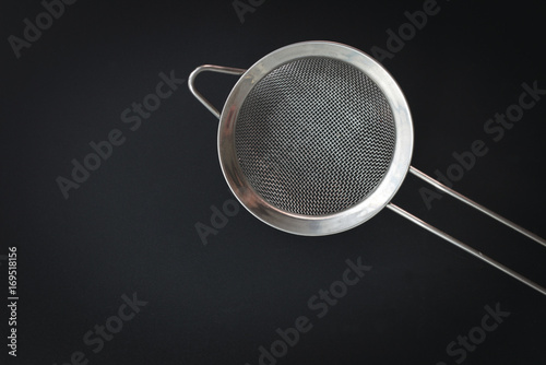 kitchen tools sieve flour or sugar filter top view on black background