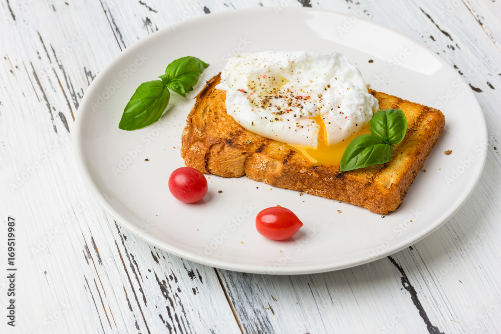 Poached egg on a piece of bread on the wooden table Poached egg on a piece of bread on the wooden table