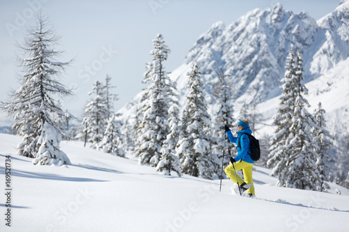 A girl walking with snowshoes in the Austrian alps