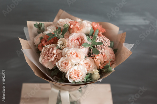 Fototapeta Naklejka Na Ścianę i Meble -  Bouquet in kraft paper. A simple bouquet of flowers and greens