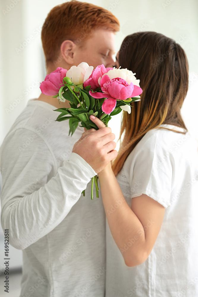 Cute young couple with bouquet of flowers at home Cute young couple with bouquet of flowers at home