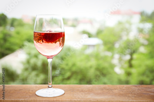 Glass of delicious strawberry wine on blurred background