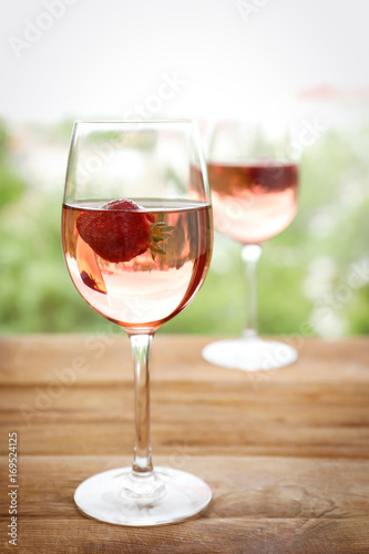 Glass of delicious strawberry wine on blurred background