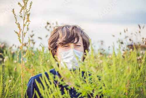 Young man in a medical mask because of an allergy to ragweed photo