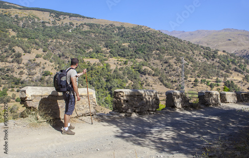 Trekker walking along Poqueira Gorge. Las Alpujarras Region, Granada, Spain photo