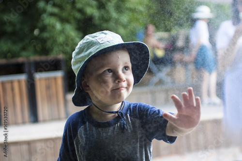 Cute toddler give five under rain  
