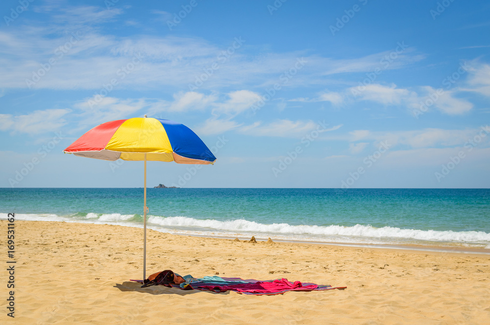 Colorful beach umbrella on the sandy beach on summer day. Naithon beach, Phuket, Thailand