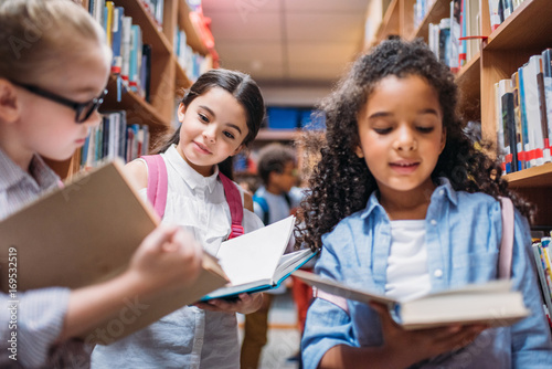 schoolgirls looking for books in library