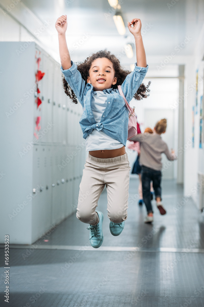 girl jumping in school corridor