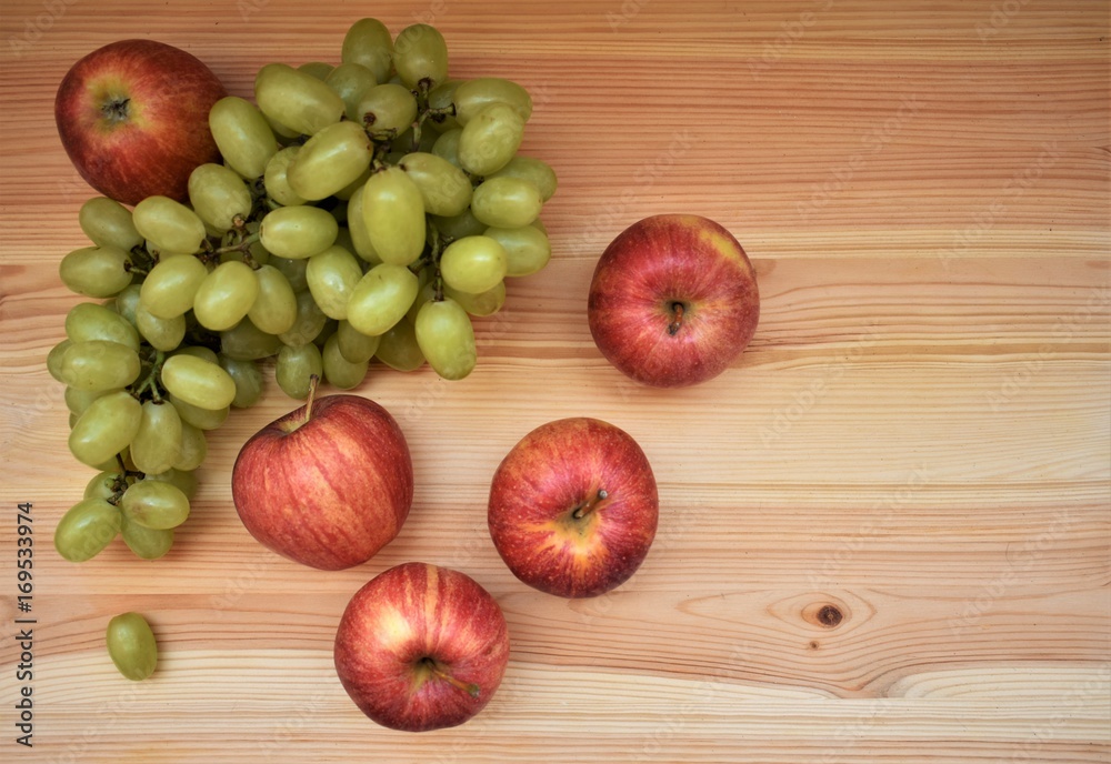Bunch of grapes and red apples on the wooden table. Bunch of grapes and red apples on the wooden table.