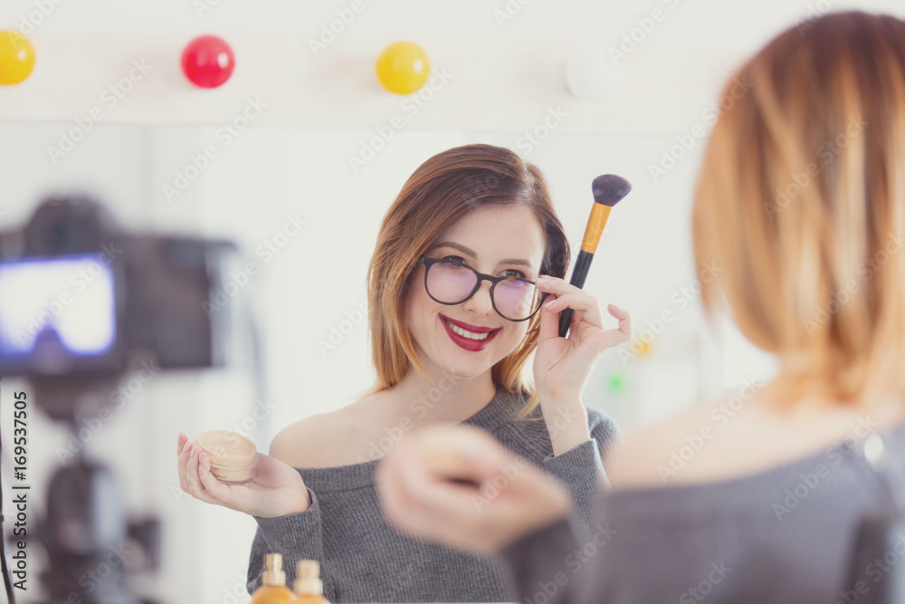  blogger woman applying cosmetics at camera