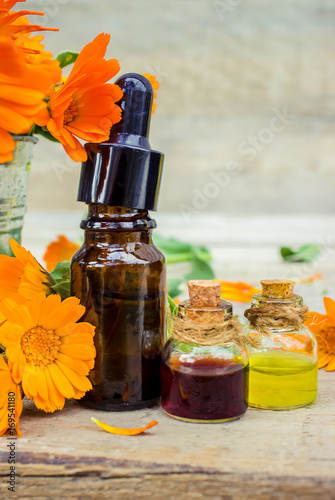 Marigold extract in a small bottle. Medicinal herbs. Selective focus.   photo