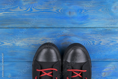 Overhead view of shoes on blue wooden floor. Shoes on a wooden background. Sneakers on a wooden floor. Sport, fitness, shoes, footwear and objects concept