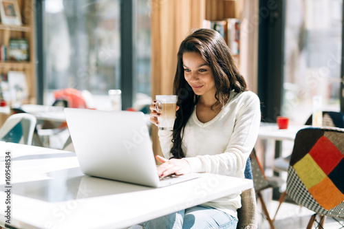 Brunette studying and enjoying coffee