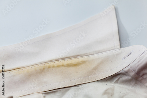 Yellow collar stain on white dirty shirt
