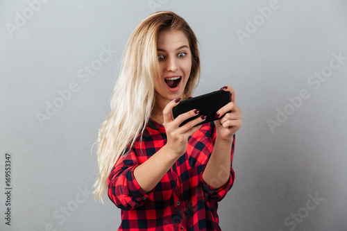 Amazing young blonde woman play games by phone.