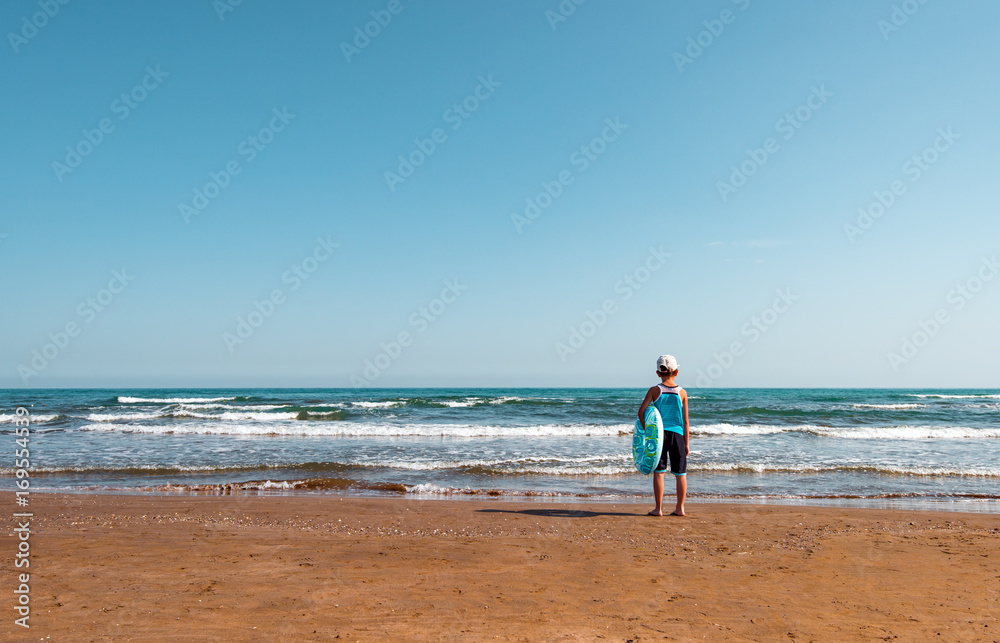 Child with a swimming ring on beach