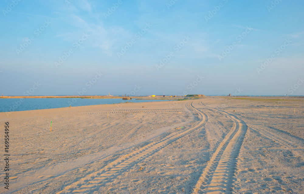 Naklejka premium Artificial island under construction in a lake at sunset in summer