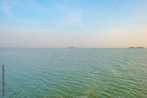 Dredgers dredging for sand in a lake at sunset in summer