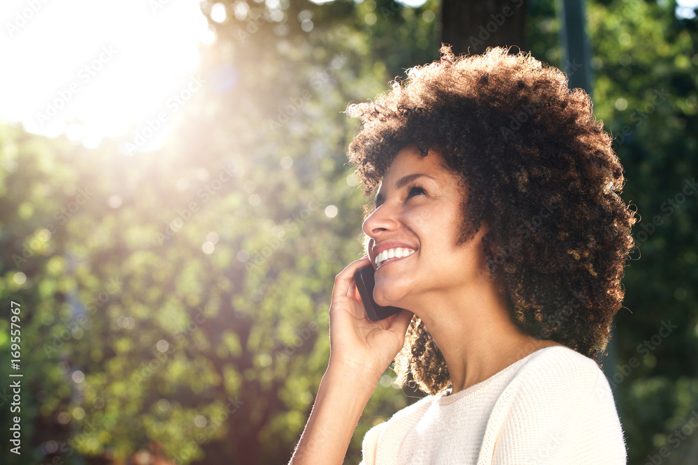 Fototapeta premium Close up smiling woman talking on mobile phone in park