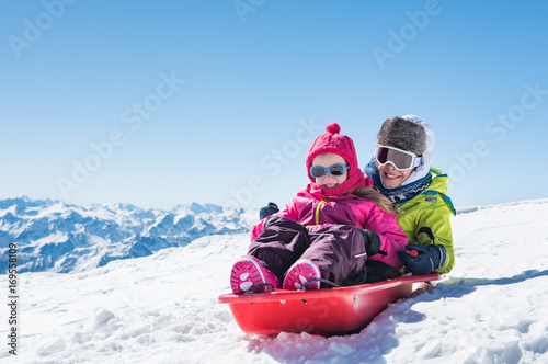 Children sledding on snow photo