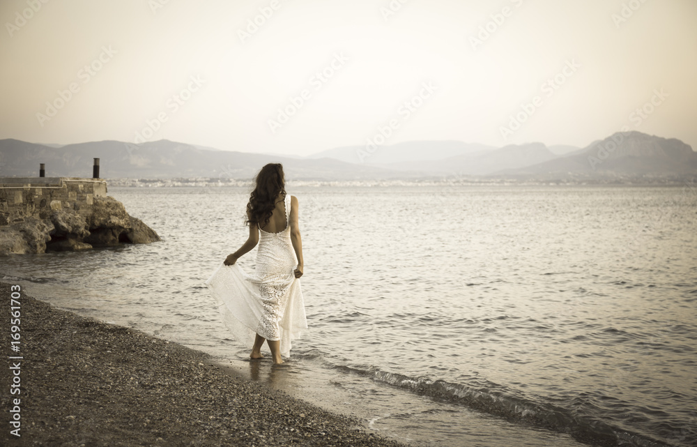Girl standing on the beach with white dress retro photo