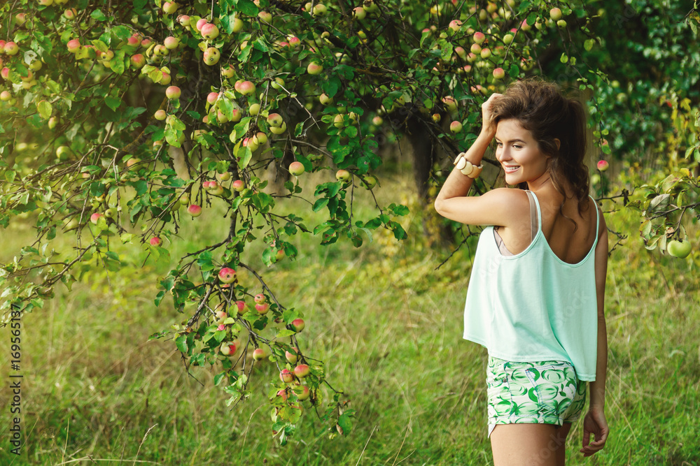 Happy woman in garden during a picking apples Happy woman in garden during a picking apples