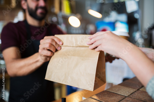 man or bartender serving customer at coffee shop photo