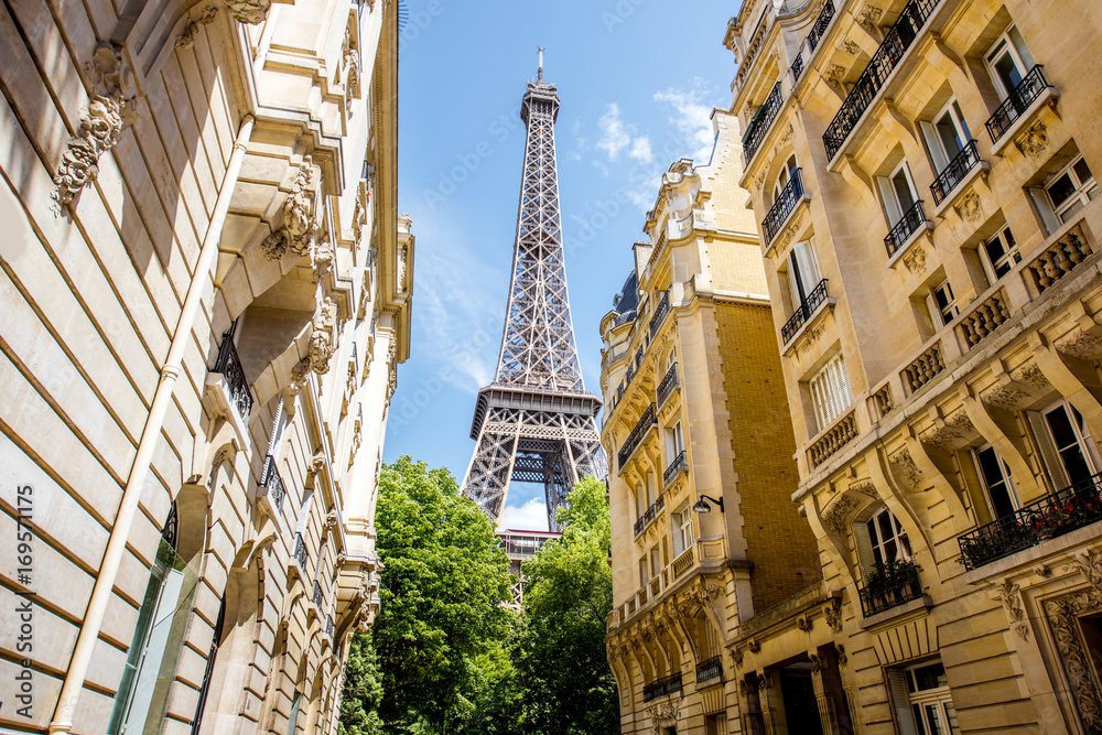 View from below on the beautiful buildings and Eiffel tower during the sunny weather in Paris