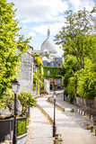 Cityscape view on the beautiful street with Sacred Heart cathedral on Monmartre hill in Paris