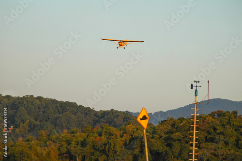 yellow single engine monoplane approaching for landing photo