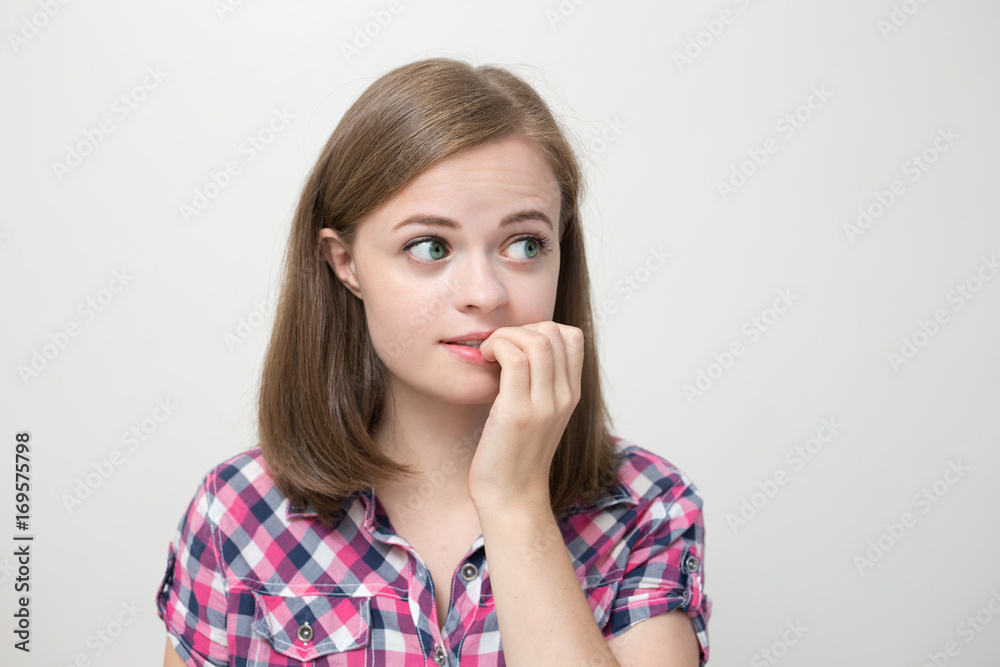 Caucasian girl gnawing, biting nails, nervous, jumpy as if thinking Caucasian girl gnawing, biting nails, nervous, jumpy as if thinking