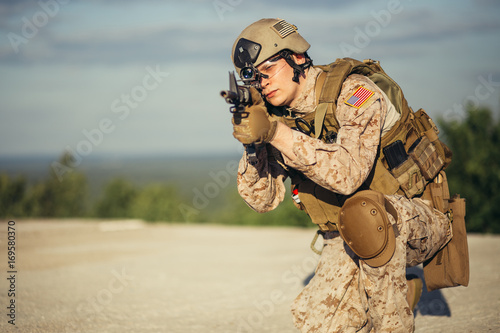 Army soldier in Protective Combat Uniform holding Special Operations Forces Combat Assault Rifle photo