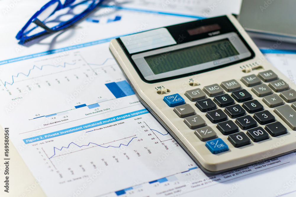 Close up business concept, Calculator, glasses and latop on summary report on table office Close up business concept, Calculator, glasses and latop on summary report on table office