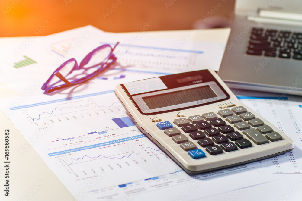 Close up business concept, Calculator, glasses and latop on summary report on table office Close up business concept, Calculator, glasses and latop on summary report on table office