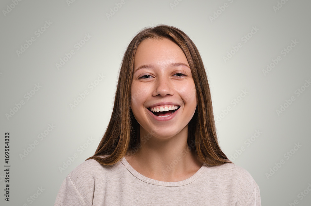 Beautiful  female looking at camera. The girl laughs. Attractive young girl portrait.  Healthy woman studio portrait.
