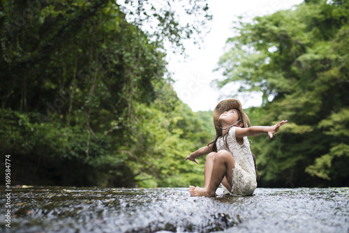 Little girl playing in the mountain stream