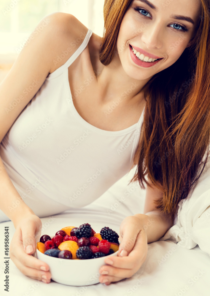 Smiling woman with plate of fruits, indoors Smiling woman with plate of fruits, indoors