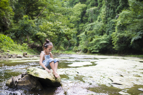 Little girl playing in the mountain stream