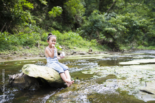 Little girl playing in the mountain stream