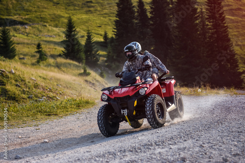 People driving quad bike on mountain road photo