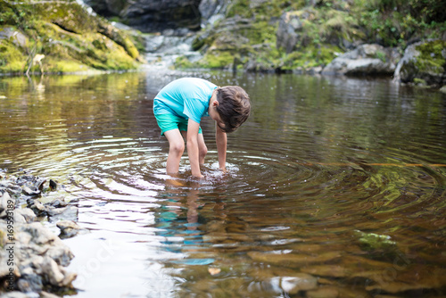 The boy is standing in the water