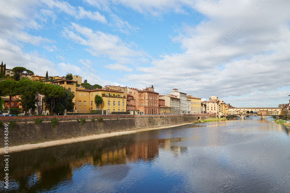 Quay of the Arno River and Ponte Vecchio Bridge in Florence, Italy on a summer sunny day
