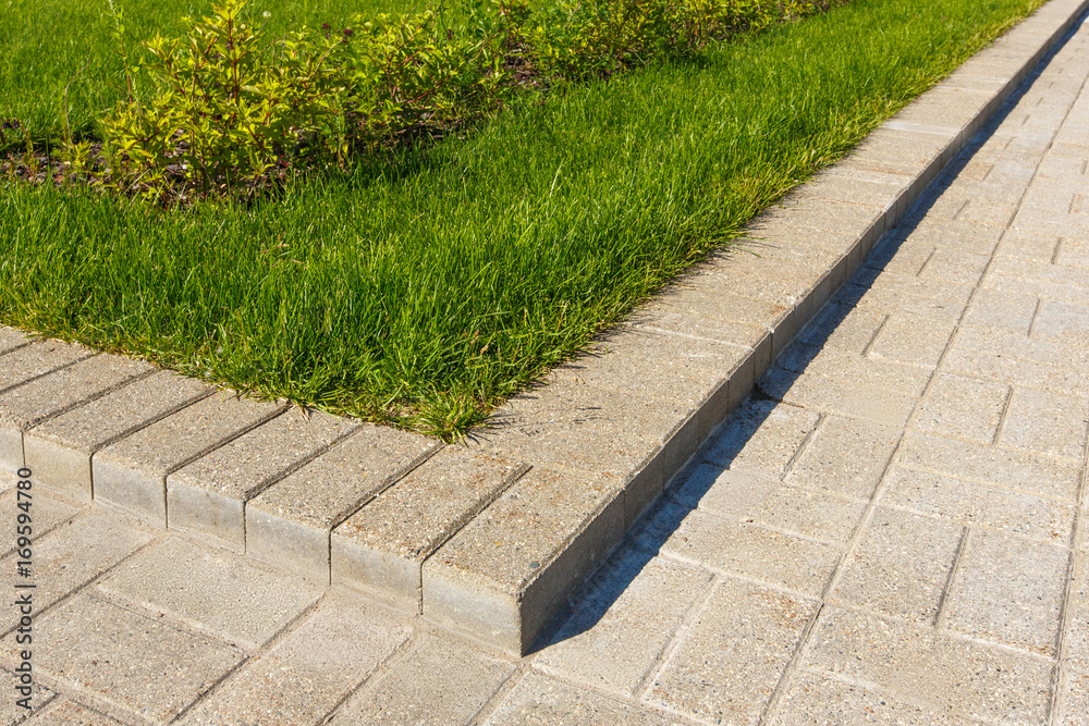 Obraz premium road and lawn divided by a concrete curb