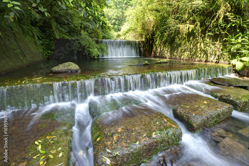 Summer scenery of beautiful waterfalls cascading down a stream in a shady jungle in Taiwan ~ Cool refreshing cascades hidden in a mysterious forest of lush greenery