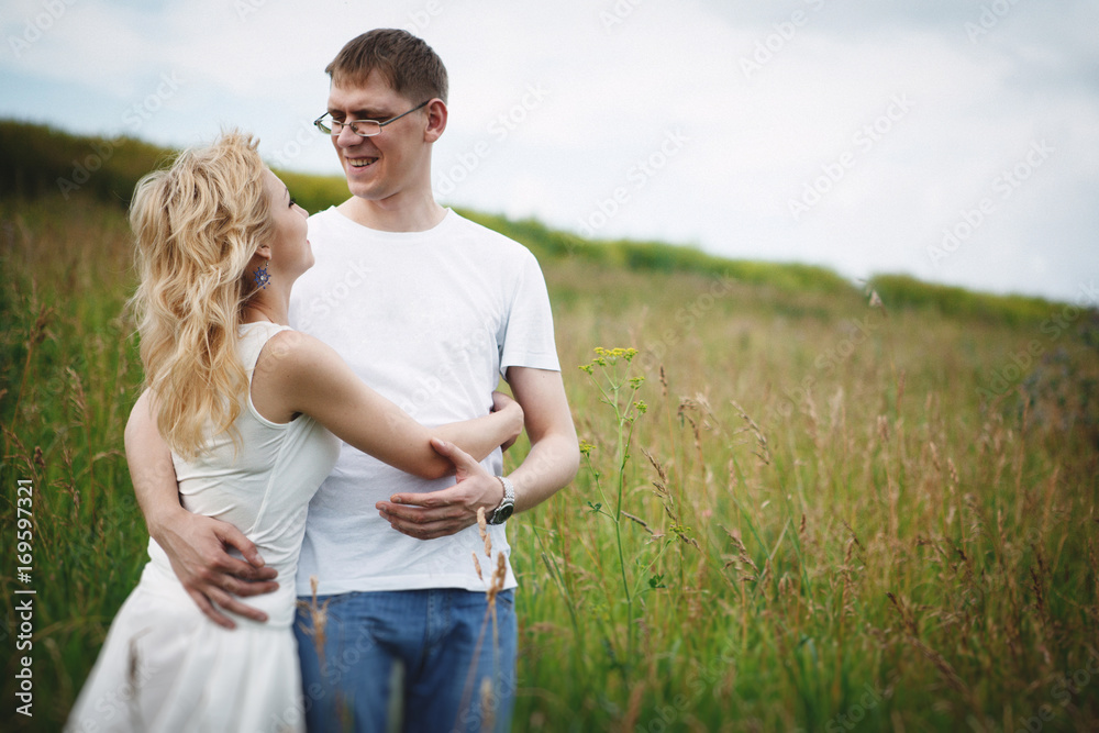 Romantic Couple Running In Field Holding Hands